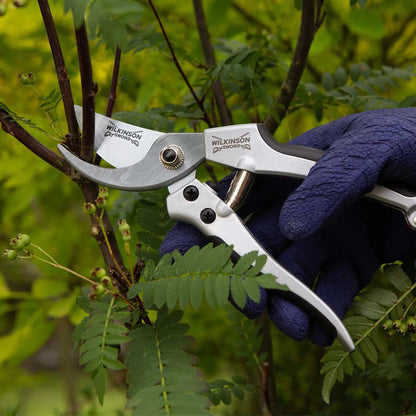 Deluxe bypass pruners with sharp steel blades and comfortable ergonomic grips shown cuttng a branch