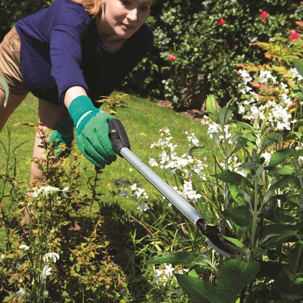 Wilkinson Sword extendable tree pruner with precision cutting head shown trimming long plants at an extendable reach