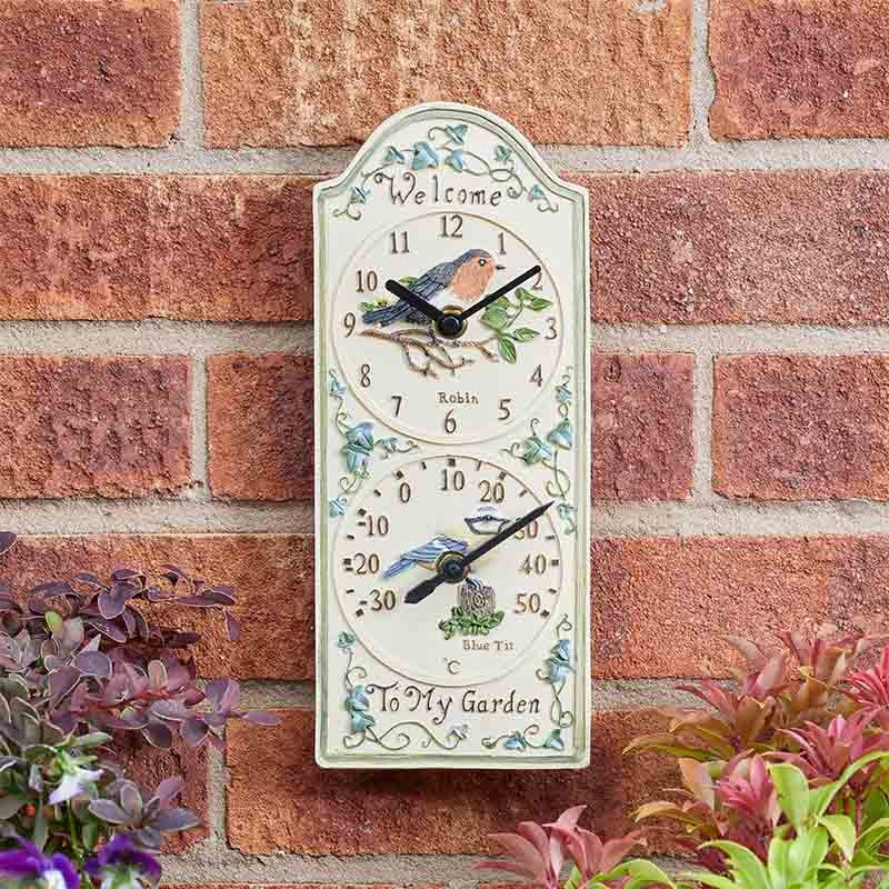 12-inch Birdberry wall clock and thermometer with weather-resistant hand-painted polyresin finish for indoor and outdoor use on outside brickwall