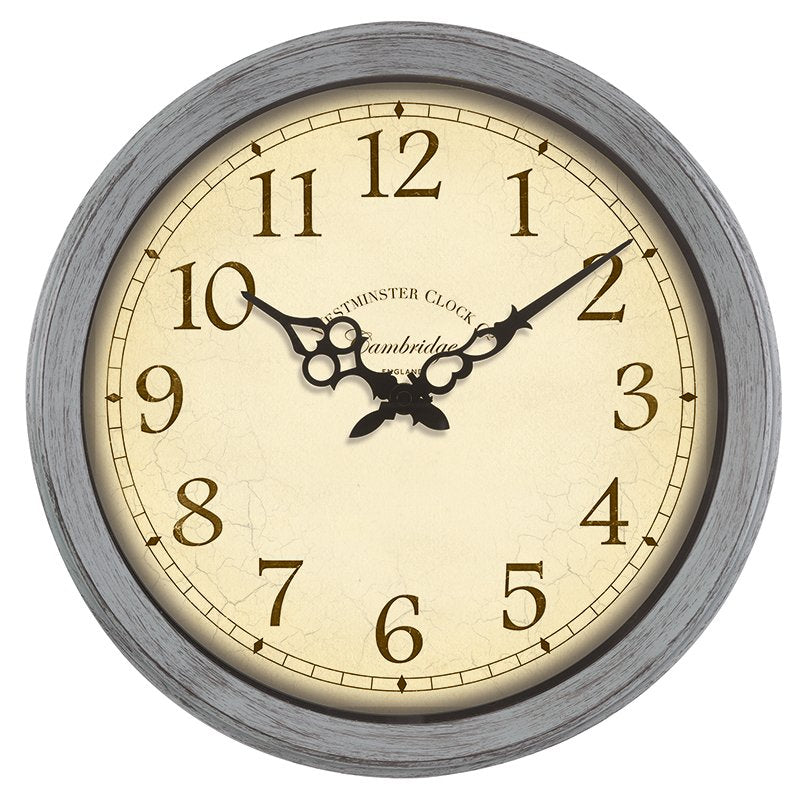 A round wall clock with a distressed gray wood-look frame, a cream-colored face, and black Arabic numerals. The brand name 'Cambridge' is printed on the dial, along with 'Cambridge Clock'.