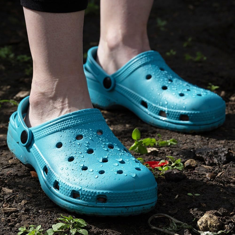 Blue clogs worn outdoors on a natural ground surface