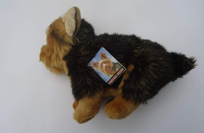 A small plush dog toy with black and tan fur, photographed on a plain white background. A small product tag is attached to its back.