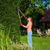 WOLF-Garten HS100T Telescopic Hedge Shears with red and yellow ergonomic handles and curved precision-ground blades, shown cutting a high up branch