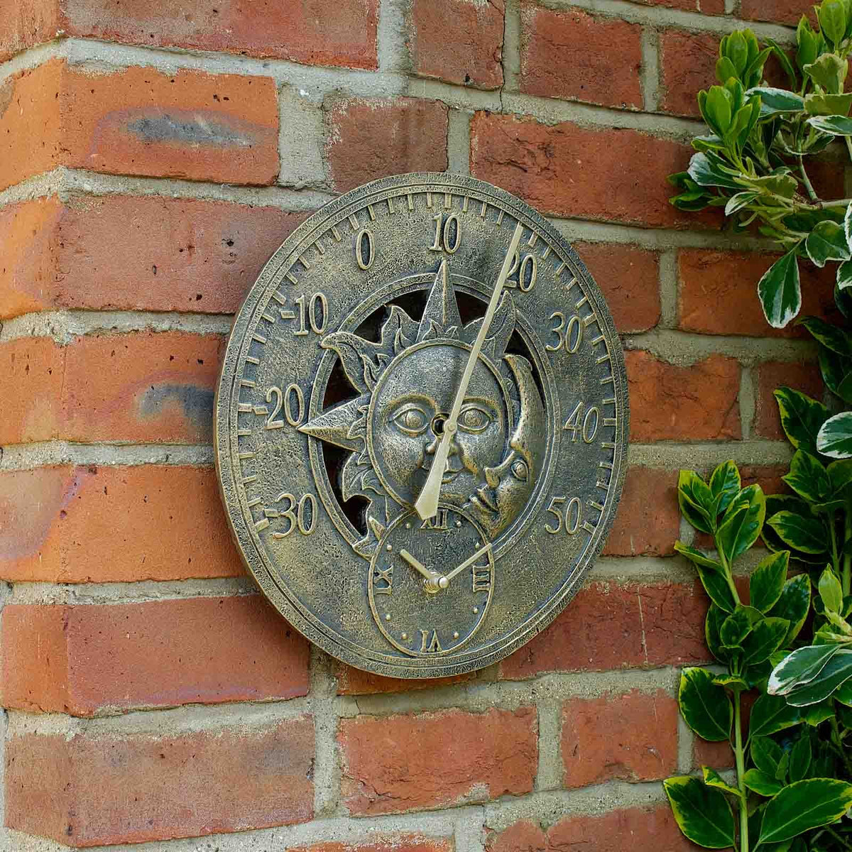 12-inch Sun & Moon wall clock and thermometer with weather-resistant hand-painted polyresin finish for indoor and outdoor use shown on a brick wall.