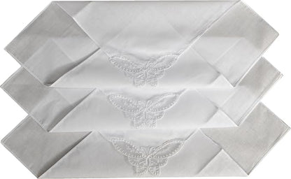 Three white folded napkins stacked diagonally, each featuring an embroidered butterfly motif near the center.