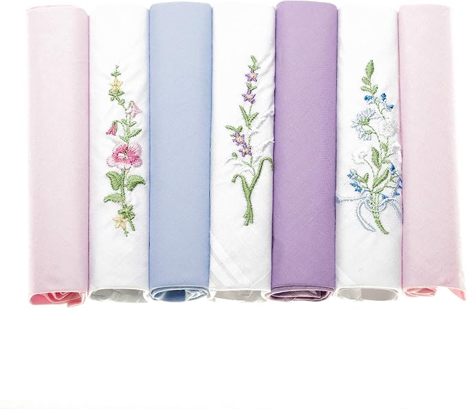 Six rolled fabric handkerchiefs in pastel shades of pink, light blue, white, lavender, and light pink, each decorated with embroidered floral designs.