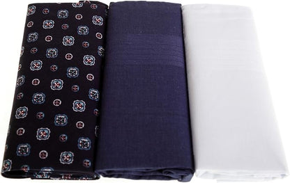 Three folded fabric pieces displayed side by side on a white background: a black fabric with a small repeating multicolor floral pattern, a dark navy fabric, and a plain white fabric.