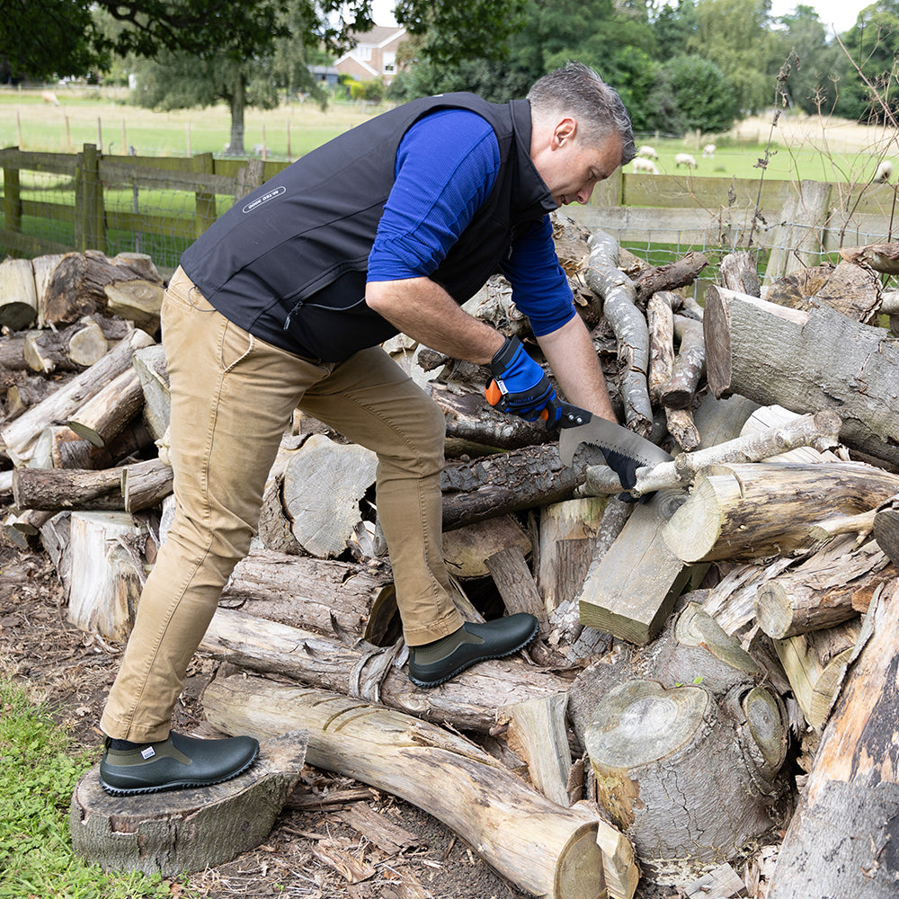 Man chopping wood with a Wilkinson Sword tree pruning saw with ergonomic grip for comfortable cutting in an outdoor setting