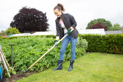 Woman gardening in a garden with Wilkinson Sword garden cultivator with rust-resistant stainless steel head.
